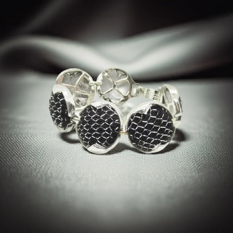Dramatic Vintage Silver Mesh and Black Panels Bracelet,This vintage bracelet exhibits a subtle medieval charm and has been crafted with six circular silver tone frames, each containing a domed disc. The discs are secured within the frames with black netting and finished with a silver mesh.