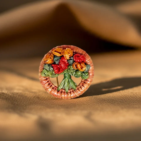 Discover the allure of this exquisite, handcrafted antique brooch, a true rarity that whispers tales of the early 1900s. Its captivating design showcases a delicate artistry, with vibrant, colored straw artfully wrapped around a classic circular frame