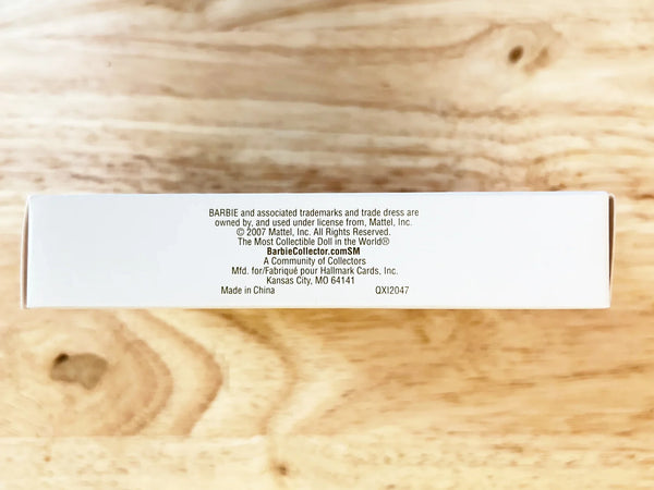 The ornament, featuring the classic and times "little black dress" appears on a pink hanger. Designed by Julie Forsyth, Hallmark Keepsake Artist, the ornament is handcrafted and the dress is actual fabric. it is perfect for both the Barbie aficionado or fashion follower. Made in China. 