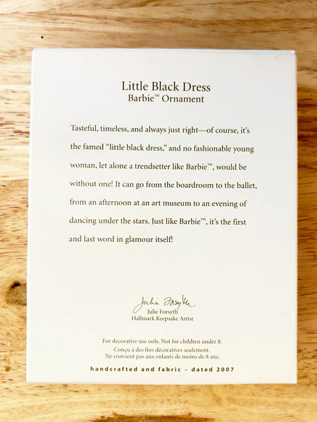 The ornament, featuring the classic and times "little black dress" appears on a pink hanger. Designed by Julie Forsyth, Hallmark Keepsake Artist, the ornament is handcrafted and the dress is actual fabric. it is perfect for both the Barbie aficionado or fashion follower. Made in China. 