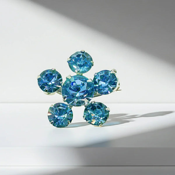 Measuring a delicate .75" across, this piece radiates timeless elegance. The unforgettable, eye-catching blue hue is beautifully complemented by the subtle "Coro" script signature discreetly placed on the back of the piece, adding a touch of authenticity and sophistication to this charming vintage treasure.