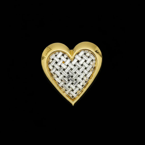 This is a bold and striking brooch by famed designer Nolan Miller. His pieces are consistently high quality and this heart shaped brooch is an excellent example of that, with it's smooth gold tone border and its perfectly set, clear and bright baguettes forming a woven-look appearance. 
