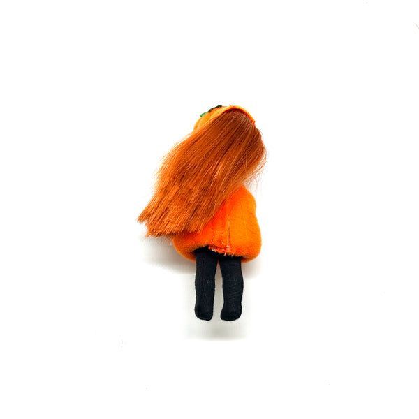 Vintage Mattel Kelly Club 2000 Halloween Party Pumpkin Jenny doll. Small doll with long brown hair wearing an orange plush pumpkin costume with a printed jack-o’-lantern face, black long sleeves, black pants, and a matching orange pumpkin cap with a green strap on a white background