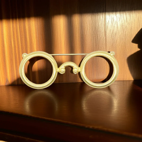 Whimsical Gold Round Eyeglasses Brooch,Add a touch of fun and whimsy to your wardrobe with this unique eyeglasses brooch. The round lenses and rounded edges give it a playful vibe, while the matte finish adds a touch of sophistication. It's well-made and in excellent condition for long-lasting wear. Perfect for adding a pop of personality to any outfit. It's spectacle-lar!