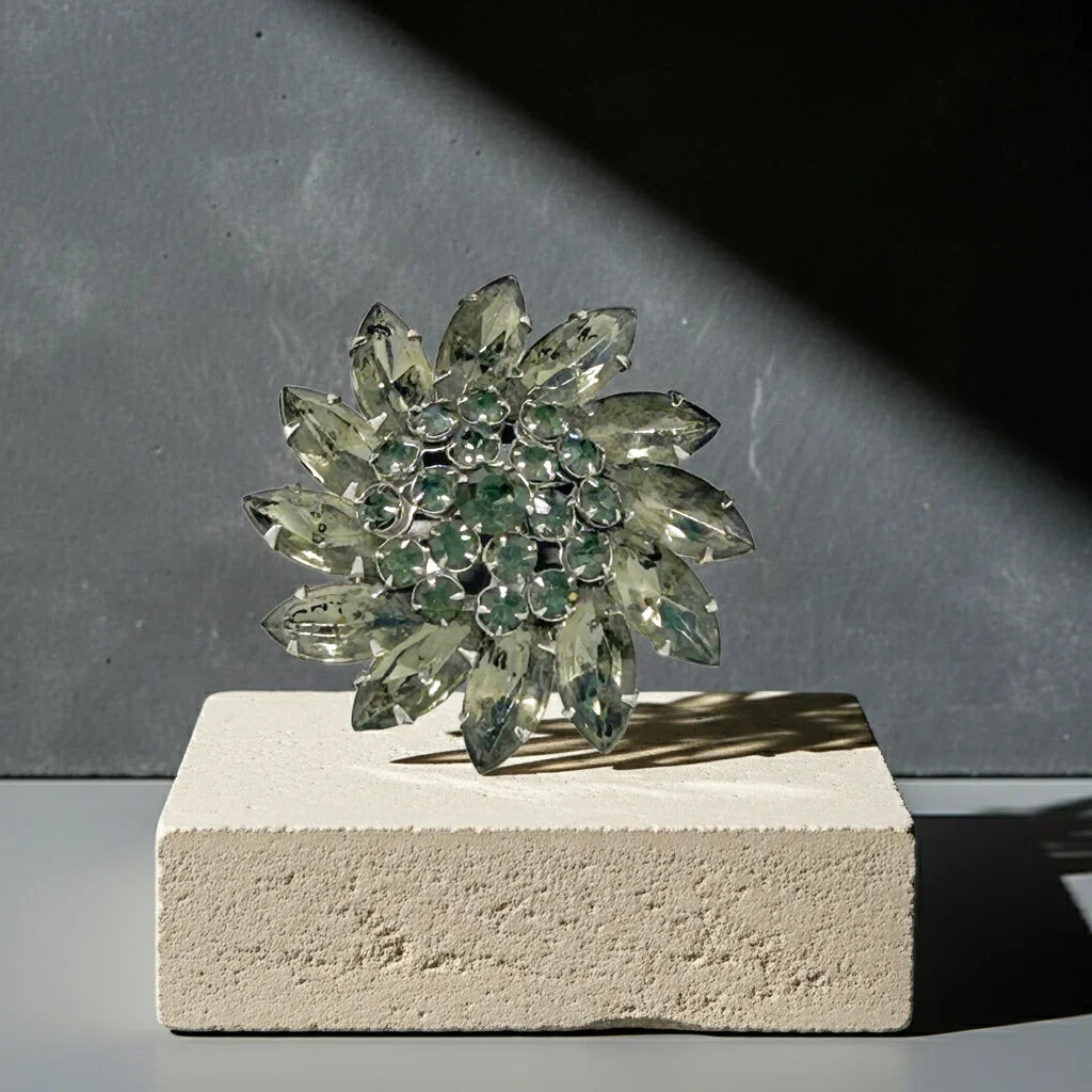 The Vintage Smoky Gray and Dark Gray Round Brooch is the ideal solution for anyone seeking a subtle yet striking enhancement to their attire. Crafted with unusual gray rhinestones, this vintage brooch offers an exquisite way to add a touch of timeless glamour.