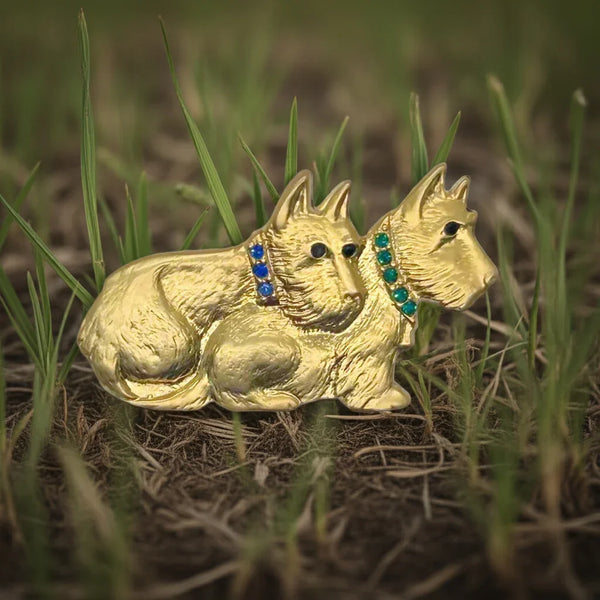 This delightful vintage brooch showcases a pair of furry terrier pals cuddled up. One has a sparkling blue collar, while the other rocks a cool green one. Their eyes are a striking dark blue/black.