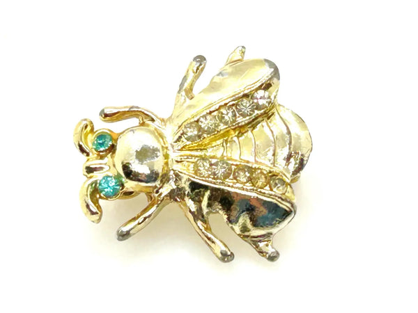 Bring a touch of springtime charm to your ensemble with this exquisite vintage bumble bee brooch. ;Featuring captivating bright aqua green eyes and wings adorned with sparkling, tiny rhinestones, this 1" piece is the ideal accent to add a radiant and nature-inspired flair to any outfit