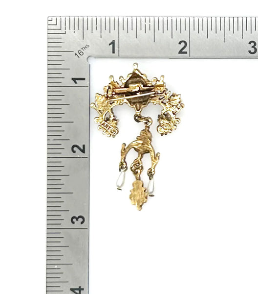 A splendid specimen of Renaissance Revival style, this Vintage ART Brooch showcases the maker's hallmark artistry through its exquisite detailing. Adorned with faux lapis, jade, turquoise, and pearl accents set within ornate gold-tone metalwork, it presents a harmonious marriage of color and design.