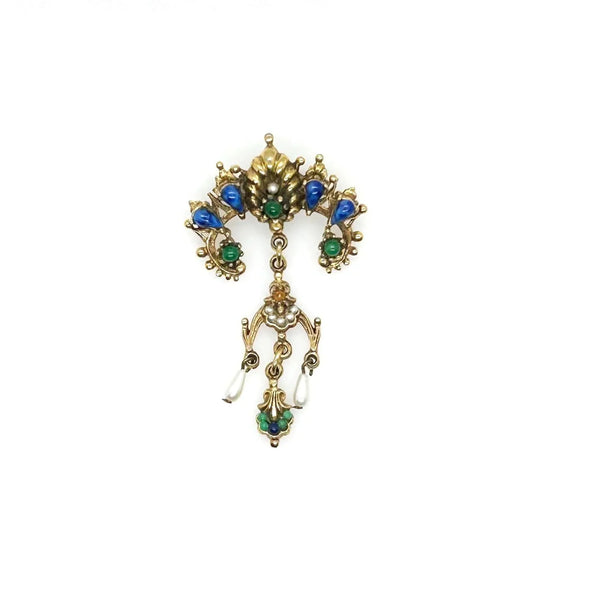 A splendid specimen of Renaissance Revival style, this Vintage ART Brooch showcases the maker's hallmark artistry through its exquisite detailing. Adorned with faux lapis, jade, turquoise, and pearl accents set within ornate gold-tone metalwork, it presents a harmonious marriage of color and design.