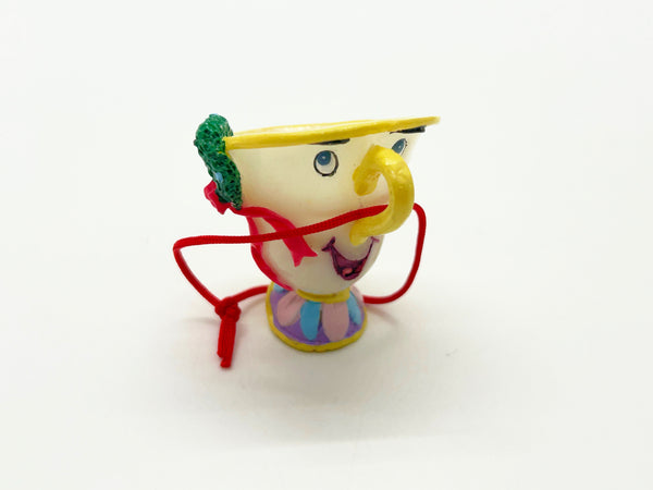 Vintage Schmid Disney Beauty and the Beast ceramic Chip teacup ornament with red hanging cord against a white background