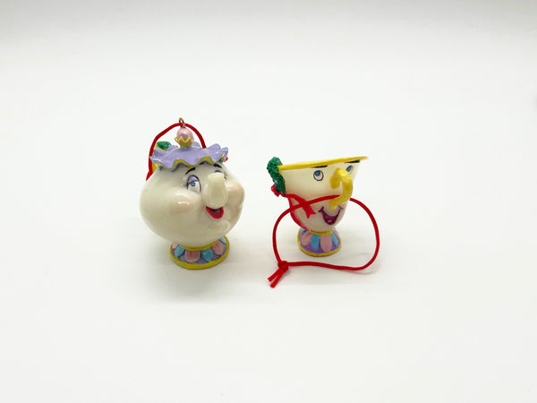 Vintage Schmid Disney Beauty and the Beast ceramic Christmas ornaments featuring Mrs. Potts and Chip with red hanging cords on a white background