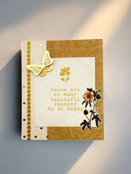 This handmade mixed media "Beautiful Reasons" album is a charming, butterfly-themed mini journal crafted with care and creativity. Featuring soothing shades of sand, olive green, and subtle red accents, it invites you to capture your most special memories and inspirations.
