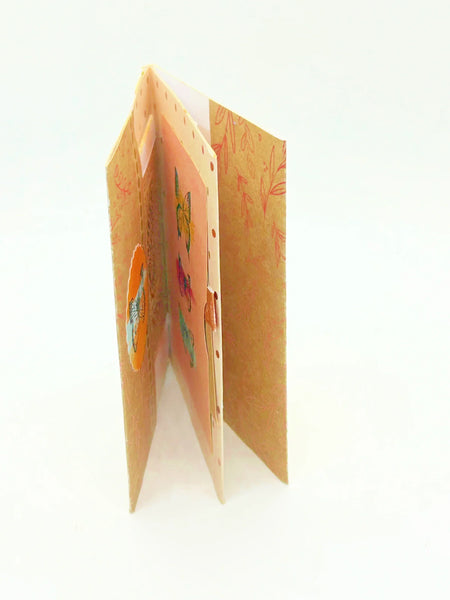 This handmade mixed media "Beautiful Reasons" mini album is a charming, butterfly-themed mini journal crafted with care and creativity. Featuring soothing shades of sand, olive green, and subtle red accents, it invites you to capture your most special memories and inspirations.