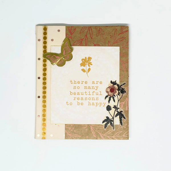 Decorative notebook with floral designs and a motivational quote on a light background