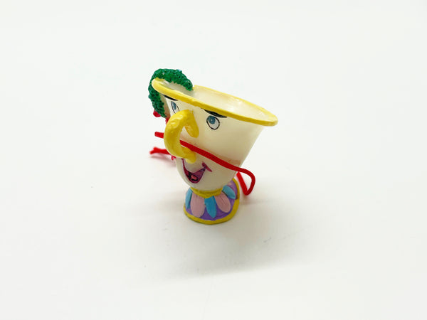 Vintage Schmid Disney Beauty and the Beast ceramic Chip teacup ornament with red hanging cord against a white background