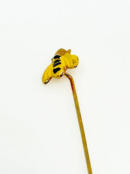 This charming vintage stick pin features a delightful black and gold bee design. The pin measures 1.75” in length, making it a perfect accessory to add a touch of whimsy to any outfit.