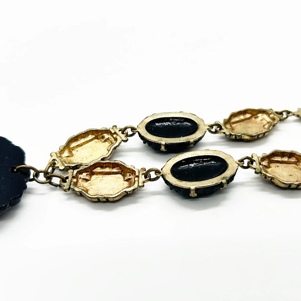Vintage Art Deco choker necklace featuring gold-tone brass filigree links, two oval black beads, and a large textured black cluster central pendant