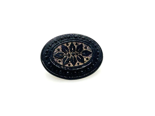 Discover this exquisite antique Victorian black glass brooch, a poignant piece of mourning jewelry originating from the mid-to-late 19th century. This captivating oval brooch boasts a delicately beaded border, framing a mesmerizing central design that evokes either a floral motif or a radiant starburst pattern. 