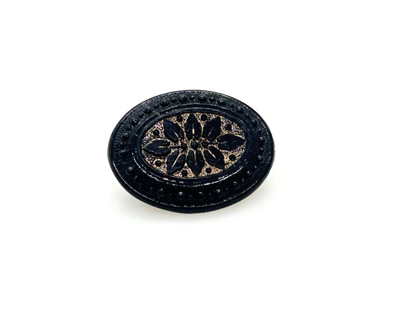 Discover this exquisite antique Victorian black glass brooch, a poignant piece of mourning jewelry originating from the mid-to-late 19th century. This captivating oval brooch boasts a delicately beaded border, framing a mesmerizing central design that evokes either a floral motif or a radiant starburst pattern. 