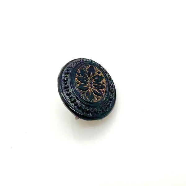 Discover this exquisite antique Victorian black glass brooch, a poignant piece of mourning jewelry originating from the mid-to-late 19th century. This captivating oval brooch boasts a delicately beaded border, framing a mesmerizing central design that evokes either a floral motif or a radiant starburst pattern. 