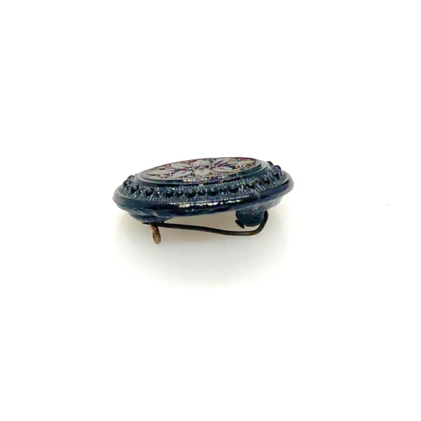 Discover this exquisite antique Victorian black glass brooch, a poignant piece of mourning jewelry originating from the mid-to-late 19th century. This captivating oval brooch boasts a delicately beaded border, framing a mesmerizing central design that evokes either a floral motif or a radiant starburst pattern. 