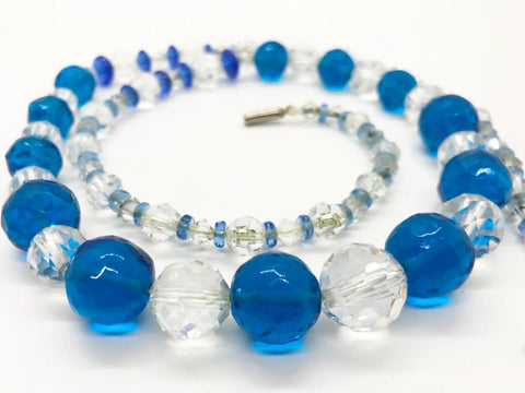 This vintage glass bead necklace is bright and sparkly. The blue beads are a bright electric blue and the clear ones glitter well. Both types of beads are graduated. This dazzling vintage necklace is sure to make a statement. 