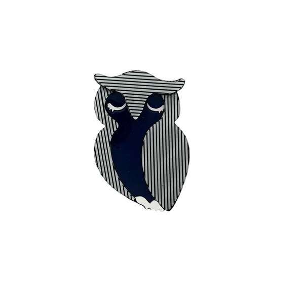Lightweight acrylic resin brooch shaped like a stylized owl. Features a bold optical art design with vertical black and white stripes and a solid royal blue body. Secure metal pin back attached.