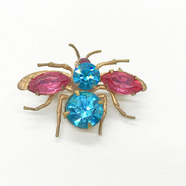 This is probably the prettiest insect you could hope to find—a truly exceptional vintage treasure you won't want to miss. Crafted from lustrous golden metal with meticulous attention to detail, this charming brooch features vibrant round aqua and pink stones that instantly draw the eye. 