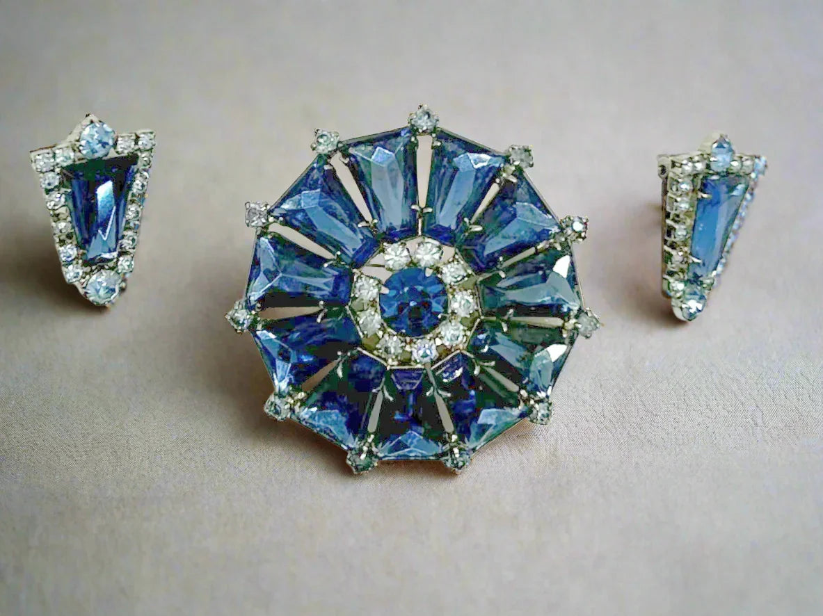 This focal point of this set are the deep blue trapezoid rhinestones set in a round frame. There have accents of lighter blue round stones, with a matching deep blue round stone in the center. The earrings are set with one of the deep blue stones and framed with the paler blue stones.