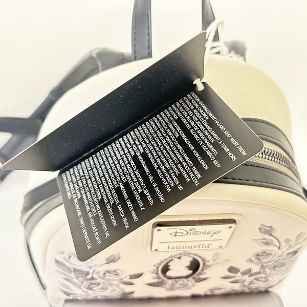 Loungefly Disney Princess Cameo Portraits Mini Backpack—a stunning 2024 release that celebrates timeless elegance! This cream vegan leather beauty showcases exquisite silhouette portraits of your favorite Disney Princesses in sophisticated black and white.