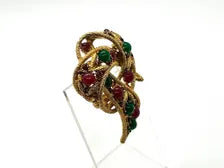 1960s vintage Capri openwork curl brooch featuring textured gold-tone metal set with green faux jade and red carnelian glass cabochons