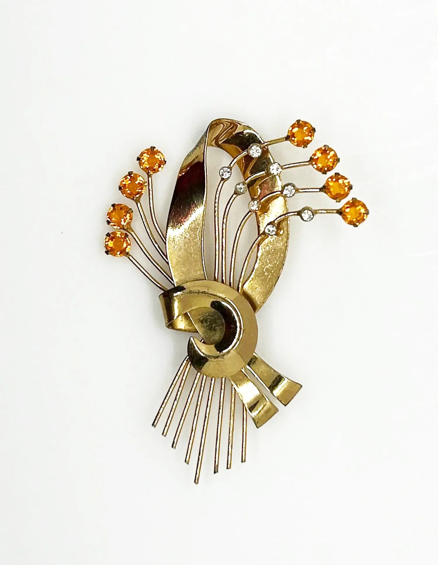 This is a massive Coro Sterling Floral Spray &amp; Ribbon Design brooch. Get mesmerized by the splendor of this vintage brooch, measuring just under 4 inches. The bouquet, intricately designed with a bow, boasts of four gold-toned lines adorned with round, citrine-orange stones.