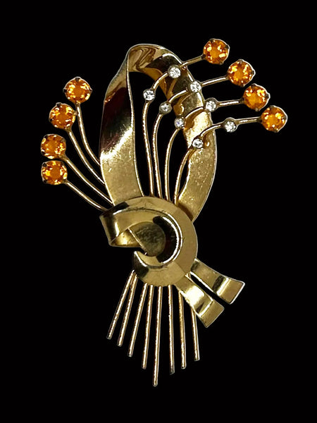 This is a massive Coro Sterling Floral Spray &amp; Ribbon Design brooch. Get mesmerized by the splendor of this vintage brooch, measuring just under 4 inches. The bouquet, intricately designed with a bow, boasts of four gold-toned lines adorned with round, citrine-orange stones of varying sizes.