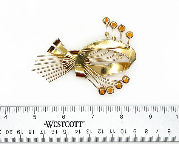 This is a massive Coro Sterling Floral Spray &amp; Ribbon Design brooch. Get mesmerized by the splendor of this vintage brooch, measuring just under 4 inches. The bouquet, intricately designed with a bow, boasts of four gold-toned lines adorned with round, citrine-orange stones of varying sizes.