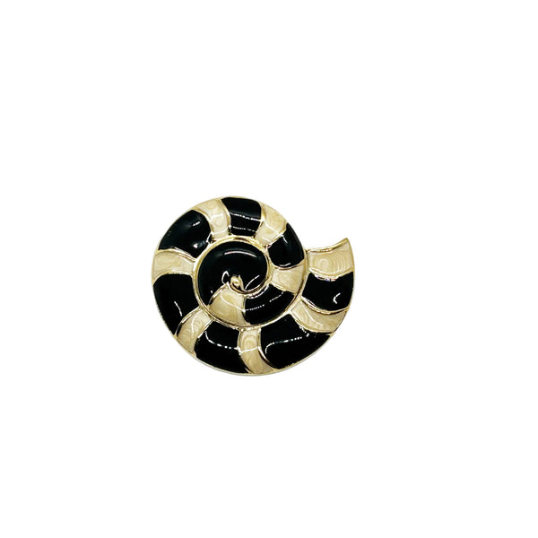 This stunning Trifari brooch captures the elegance of Art Deco design with its spiral seashell silhouette. Crafted in gold-tone metal, it features striking black enamel paired with creamy golden-sand enamel in a sophisticated moire finish.