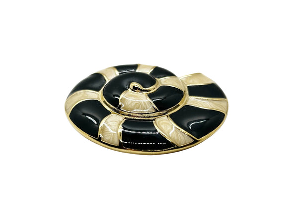 This stunning Trifari brooch captures the elegance of Art Deco design with its spiral seashell silhouette. Crafted in gold-tone metal, it features striking black enamel paired with creamy golden-sand enamel in a sophisticated moire finish.