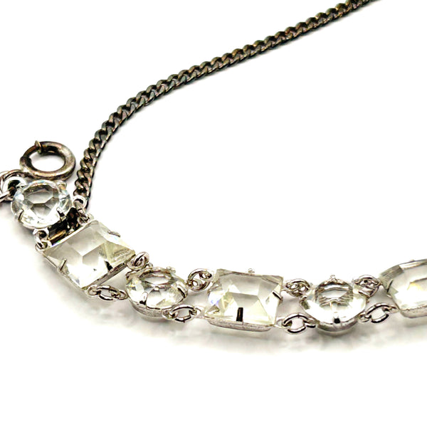 Vintage Art Deco style clear rhinestone geometric bracelet with alternating round and square-cut crystal links in a silver-tone setting on a plain white background