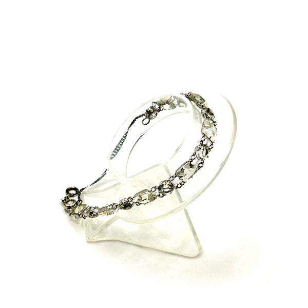 Vintage Art Deco style clear rhinestone geometric bracelet with alternating round and square-cut crystal links in a silver-tone setting on a plain white background