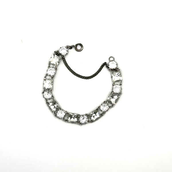 Vintage Art Deco style clear rhinestone geometric bracelet with alternating round and square-cut crystal links in a silver-tone setting on a plain white background