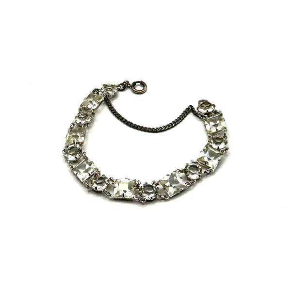 Vintage Art Deco style clear rhinestone geometric bracelet with alternating round and square-cut crystal links in a silver-tone setting on a plain white background