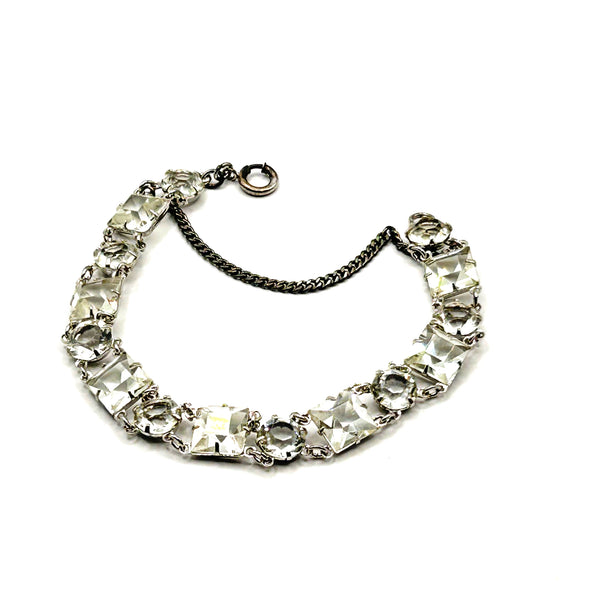 Vintage Art Deco style clear rhinestone geometric bracelet with alternating round and square-cut crystal links in a silver-tone setting on a plain white background