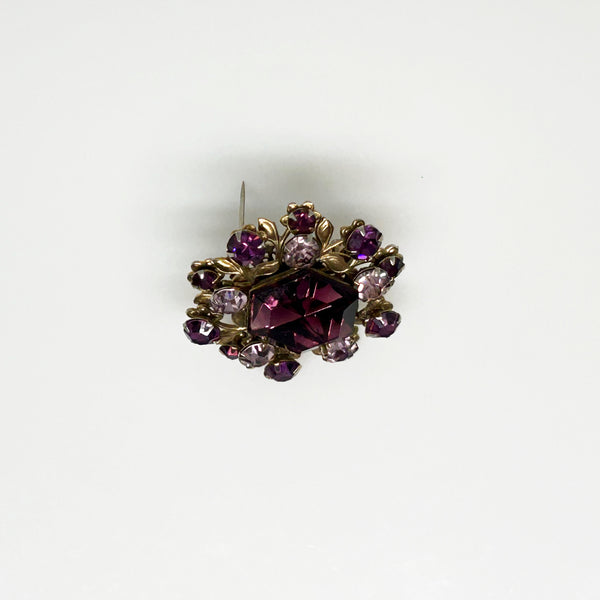 This dazzling brooch features a large octagonal purple stone at its center, surrounded by sparkling lavender and purple round stones. Its two-tiered design highlights the bezel-set centerpiece, making it truly eye-catching. With intricate details that showcase exceptional Czech craftsmanship,