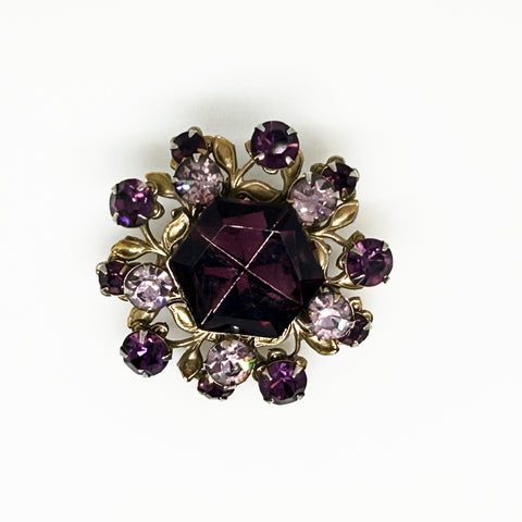 This dazzling brooch features a large octagonal purple stone at its center, surrounded by sparkling lavender and purple round stones. Its two-tiered design highlights the bezel-set centerpiece, making it truly eye-catching. With intricate details that showcase exceptional Czech craftsmanship,