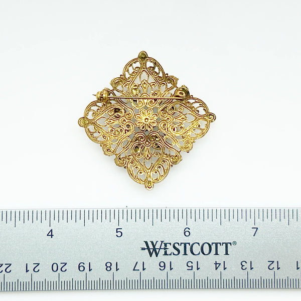 Intricate Vintage Gold Tone Brooch with Ruby Red Stones - Add timeless charm with this ornate brooch featuring deep ruby red stones. Perfect statement piece. Shop now!