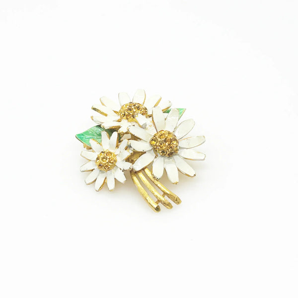 This is a cheerful vintage daisy brooch with enameled petals and a domed golden rhinestone center. It measures 2" long and is in good condition.