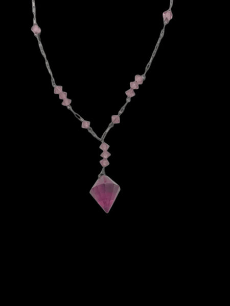 This stunning vintage crystal necklace showcases clusters of deep purple bicone beads, interspersed with sleek paper clip chains. It culminates in a magnificent faceted diamond-shaped stone. Measuring 16.5 inches in length, with a drop of 1.5 inches from the center, this piece exudes elegance and sophistication.