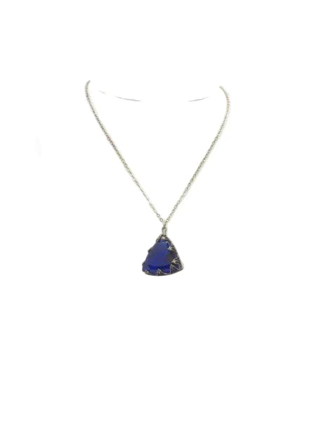 This extraordinary Art Deco pendant necklace is a true collector's treasure, featuring a stunning triangular faceted cobalt blue glass stone that shifts between rich cobalt and mesmerizing violet tones depending on the light.
