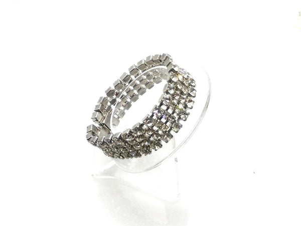 This vintage rhinestone bracelet provides an elegant touch to any ensemble. Featuring four rows of meticulously prong-set rhinestones, it measures approximately 7 inches in length and 0.75 inches in width. 