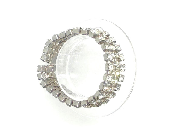 This vintage rhinestone bracelet provides an elegant touch to any ensemble. Featuring four rows of meticulously prong-set rhinestones, it measures approximately 7 inches in length and 0.75 inches in width. 
