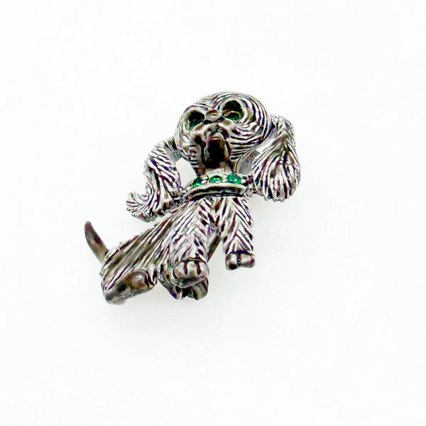 This vintage brooch shows an adorable, floppy eared puppy dog. He has bright green eyes and collar and wagging tail. He's just waiting for you!! His coat is well detailed in silver tone metal. He or she measures 1 3/4" tall and is marked "Gerry's" in capitals on the white enamel back.